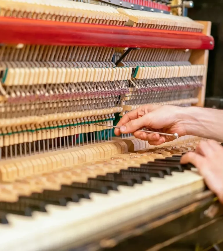 Regulation einer Klaviermechanik, ein Klavierbauer beim Unterstellen
